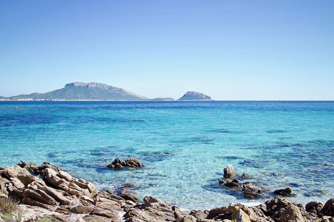 Costa rocciosa di Santa Maria con acque turchesi e isole sullo sfondo